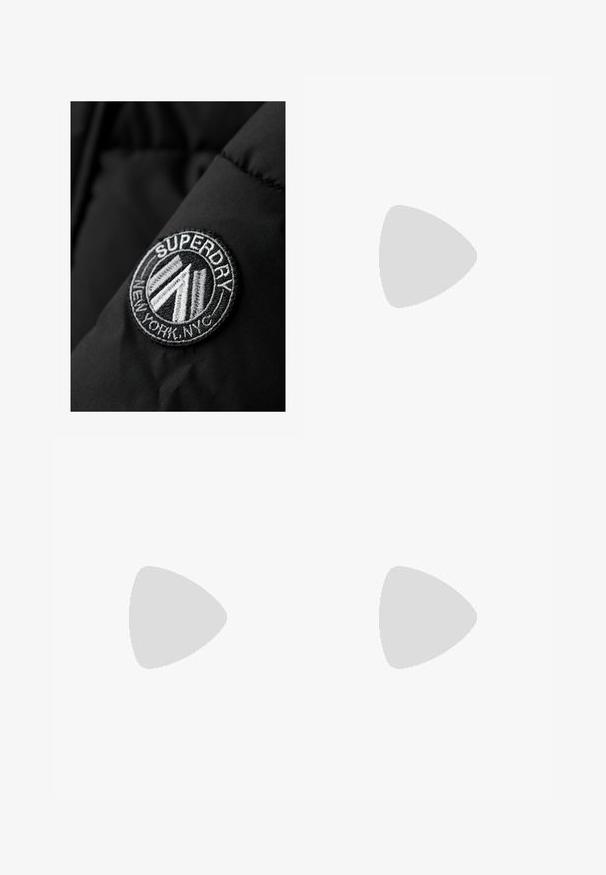 Superdry & Co CITY CHEVRON PADDED - Winter coat - black; Two long-sleeve shirts: one white and one black. Made of smooth fabric, featuring round necklines and fitted shapes with straight hemlines.; Light gray, wide-leg pants made of soft fabric, featuring scattered black text and graphic patterns throughout, with an elastic waistband and drawstring.; Black sneakers with a sleek design, featuring three white stripes, a black tongue, and a textured brown rubber sole. Accents of gold lettering.