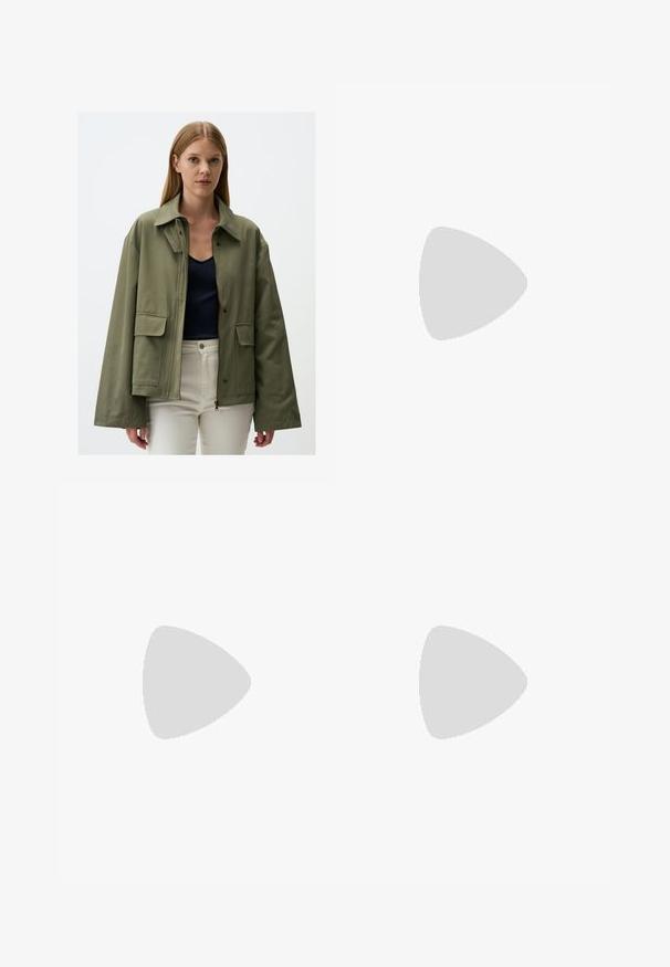 Olivgrüne Jacke aus strukturiertem Stoff, mit einem Reißverschluss, zwei vorderen Taschen und einem breiten Kragen. Über einem marineblauen Oberteil getragen.; Weißes, geripptes Tank-Top aus Baumwolle mit einem runden Halsausschnitt und einem schwarzen gestickten Logo auf der oberen linken Seite. Schlichtes Design, ärmellos.; Weiße Leinen-Hosen mit weitem Bein, elastischem Bund, Kordelzug und einem lockeren, fließenden Schnitt. Sie haben saubere Kanten und keine sichtbaren Muster.; Weiße, offene High-Heel-Mules mit glatter Oberfläche, minimalistischer Gestaltung und schlankem Absatz, ausgestattet mit einem subtilen braunen Akzent auf der Sohle.