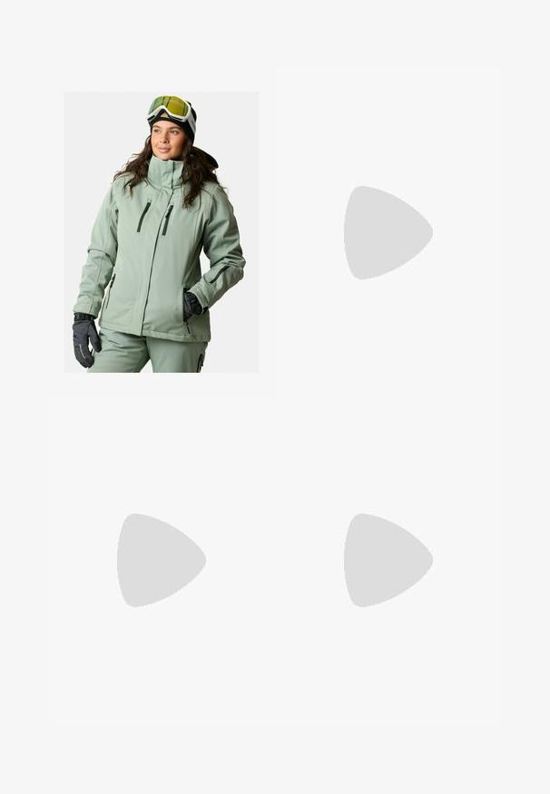 Jasnozielona kurtka softshell z wysokim kołnierzem, wieloma kieszeniami na zamek i zamkiem przy mankietach. Połączona z czarnymi rękawicami i goglami.; Czarna koszulka z długim rękawem z bawełny z okrągłym dekoltem. Posiada niewielkie białe logo po lewej stronie na piersi. Prosty design i fason.; Czarne nylonowe spodnie cargo z odpinanymi nogawkami, regulowanymi mankietami, wieloma kieszeniami oraz logo na prawej nogawce. Gładka, lekka tekstura.; Beżowe i kremowe buty sportowe z teksturowanej siateczki, wspierającymi nakładkami oraz gumową podeszwą z wzorem bieżnika zapewniającym przyczepność.