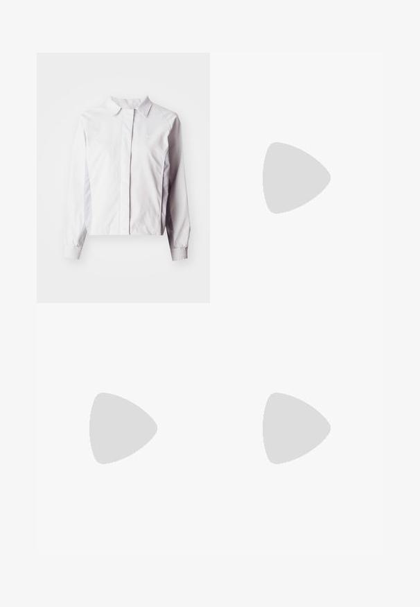 Casaco branco de manga longa com gola tipo colarinho, apresentando punhos elásticos e uma textura suave. Logo discreto da Nike na frente.; T-shirt de algodão branco com decote redondo e mangas curtas. Apresenta um pequeno logo preto da Nike no peito. Design simples e sem adornos.; Calças atléticas largas brancas com uma cintura canelada e um discreto detalhe de logótipo. Tecido suave com um corte relaxado e terminações ajustadas.; Sneakers de couro branco com detalhes em amarelo e lavanda, bico arredondado, cadarços planos e sola de borracha texturizada. Usados com meias brancas.