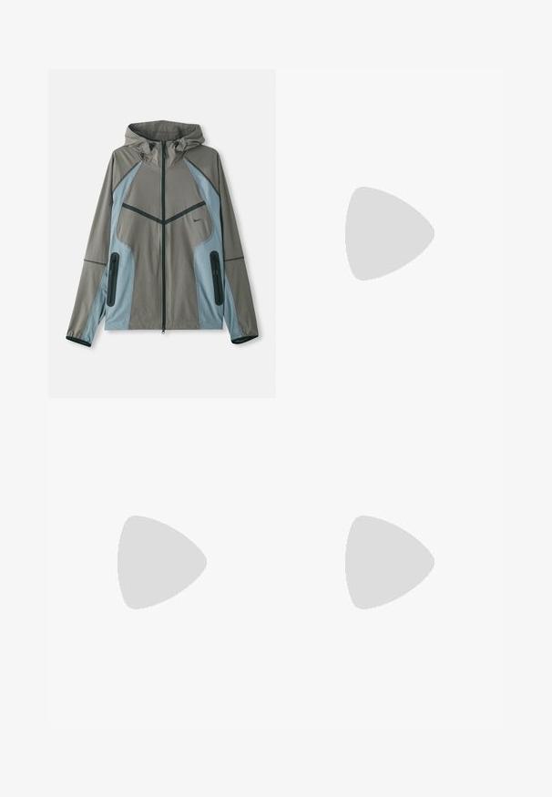 Casaco resistente à água com capuz, apresentando um corpo cinza e detalhes azuis, bolsos com fecho éclair e costura em contraste sobre uma textura suave.; Três tops em algodão de alças brancas com nervuras. Apresentam um decote redondo e pequenas etiquetas pretas perto da bainha. Disponíveis em vários tamanhos.; Calças de cargo leves em nylon preto, com cintura elástica, cordão ajustável e múltiplos bolsos em camadas nas pernas.; Sapatos atléticos brancos com sobreposições texturizadas, sola espessa e detalhes em cinza. Usados com meias brancas até ao tornozelo e calções verdes sobre uma superfície azul.