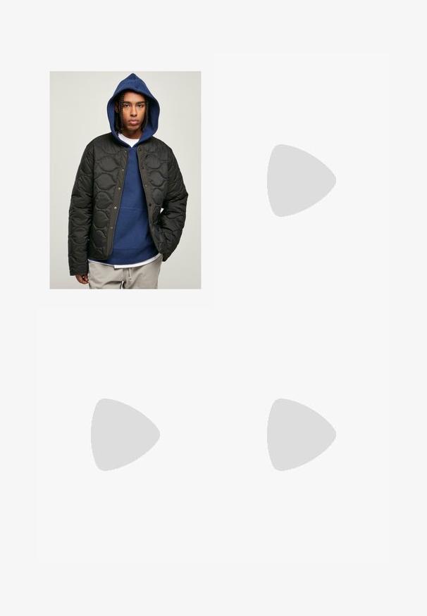 Svart kviltad jacka med glänsande yta och tryckknappar, bärs över en blå hoodie. Modellen har flätat hår.; Grå t-shirt i bomullsblandning med svart Nike-logotyp; har en liten Nike-etikett på sidokanten; enkel design, korta ärmar.; Beiga cargobyxor i ett lätt bomullsmaterial. Har elastiska mudd, flera sidofickor och en knappstängning.; Vita lädersneakers med perforeringar, rund tå, platt sula och tjocka snörning, med en synlig swoosh-logga och "AIR" på hälen.