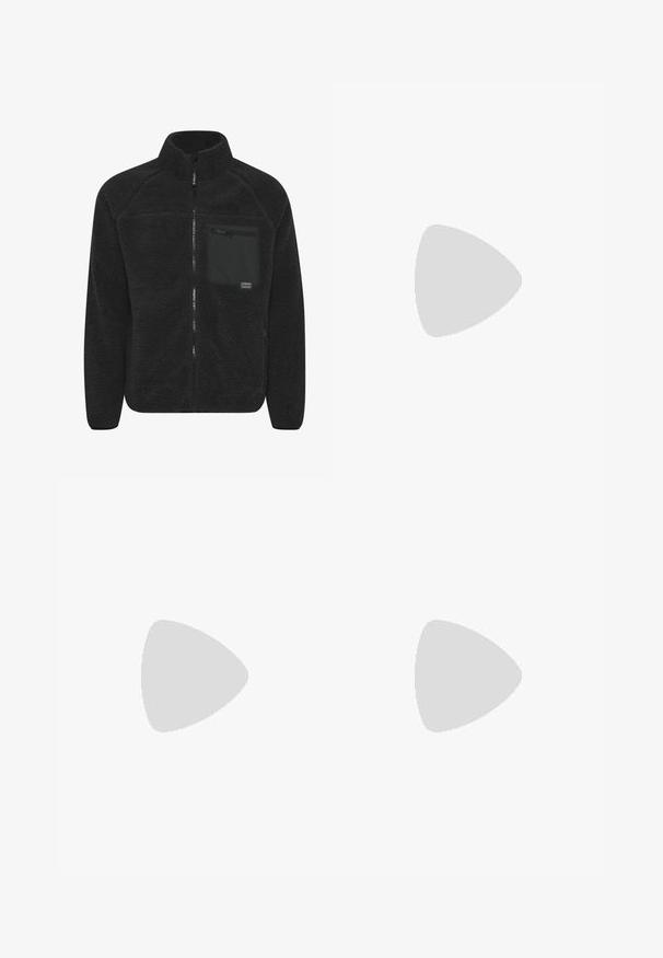 Zwarte fleece jas met een hoge kraag. Voorkant met ritssluiting en een borstzak met een rits. Zacht, gestructureerd materiaal.; Grijze katoenen t-shirt in een blend met zwarte Nike-logo; heeft een klein Nike-label aan de zijkant bij de zoom; eenvoudig ontwerp, korte mouwen.; Beige cargobroek van lichtgewicht katoenen materiaal. Kenmerkend zijn de elastische boorden, meerdere zijzakken en een knoopsluiting.; Witte leren sneakers met perforaties, ronde neus, vlakke zool en dikke veters, met een zichtbare swoosh-logo en "AIR" op de hiel.