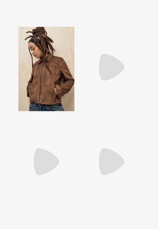 Mlada osoba s dugim smešnim dredovima stoji naslonjena na svijetli drveni zid, noseći smeđi antilop jaknu i plave traperice, s rukama u džepovima i glavom nagnutom prema dolje.; Smeđi kratki rukav majica od mekog materijala, s okruglim izrezom i opuštenim krojem. Nema vidljivih uzoraka ili naglasaka.; Smeđe hlače širokog kroja s glatkom teksturom, koje imaju visok struk i nabore sprijeda. Tkanina je lagana i slobodno se kreće.; Smeđe zamšaste sandale s visokim potpeticama, otvorenim prstima, podesivom trakicom oko gležnja i prugastom platformom.; Smešane sunčane naočale s pravokutnim lećama, debelim okvirom i tamnim lećama. Glatka tekstura i minimalistički dizajn.