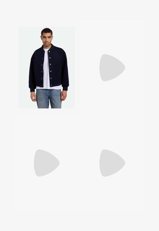 Giacca varsity blu navy con bottoni a pressione, polsini e orlo a coste, indossata sopra una maglietta bianca, abbinata a jeans blu. Texture morbida.; T-shirt in cotone nero con maniche corte, colletto rotondo e un piccolo logo Nike bianco sull'upper sinistra del petto. Texture liscia. Taglio classico.; Pantaloni casual neri con elastico in vita, tasche laterali e taglio dritto su uno sfondo uniforme.; Scarpe sportive nere con tessuto testurizzato e suole in gomma, dotate di lacci elastici e un accento blu sul tallone. Indossate con pantaloni in denim chiaro.