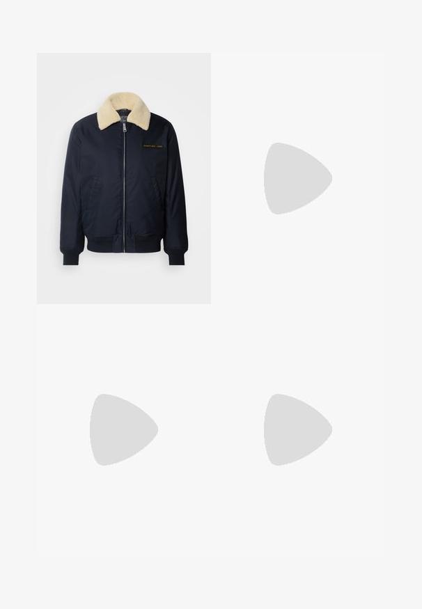 Chaqueta bomber navy con un cuello de piel sintética color crema, bolsillos laterales, puños de canalé, cierre frontal con cremallera y logo bordado en dorado en el pecho.; Camiseta de cuello redondo azul marino hecha de una suave mezcla de algodón, con mangas cortas y un corte regular. Sin patrones ni acentos visibles.; Pantalones de mezclilla negra con corte recto, diseño de cinco bolsillos y cierre frontal con botón. Textura suave con detalles de costura mínimos.; Zapatillas negras con parte superior de cuero con textura de cocodrilo en relieve, puntera redondeada y una suela de goma blanca contrastante con un acabado suave.