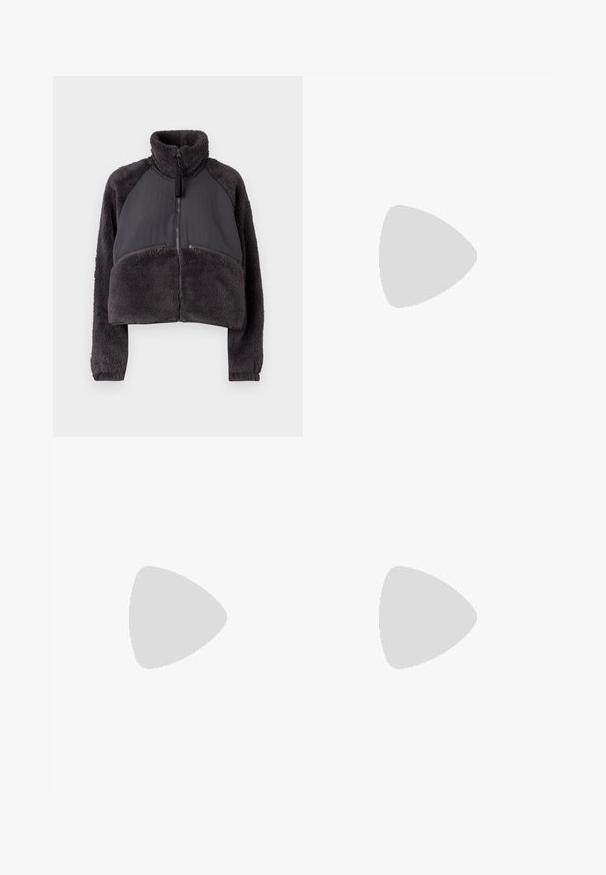 Giacca tagliata in grigio scuro con corpo in pile e pannelli in tessuto liscio. Presenta un colletto alto e tasche frontali con zip.; Maglia a maniche lunghe bianca a collo alto realizzata in tessuto morbido ed elastico. Presenta un colletto alto e un design aderente, senza motivi o decorazioni visibili.; Jeans a gamba larga di colore azzurro chiaro realizzati in denim, con vita alta, design a cinque tasche e leggera scoloritura per un aspetto vissuto.; Sneakers platform bianchi realizzati in materiale sintetico liscio, con punta arrotondata, design con lacci e suola in gomma texture. Accento nero nel tallone.