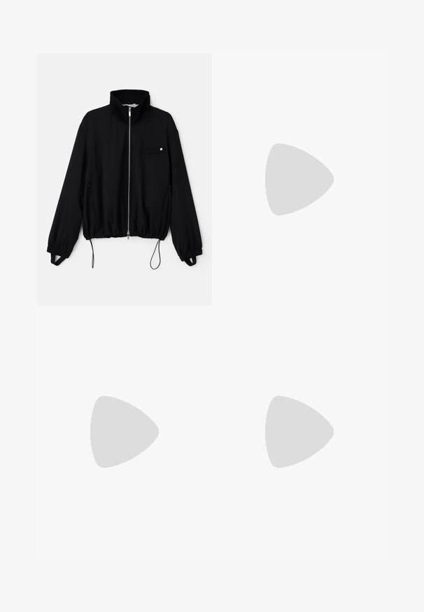 Black zip-up jacket with high collar, elastic cuffs, and a drawstring hem. Features a small front pocket and smooth fabric texture.; Black oversized T-shirt with white text "Kids of the Loud Kingdom," "Concrete Born," "Unbreakable," and a detailed eagle graphic below.; Han Kjøbenhavn PANELLED TRACK TROUSERS - Tracksuit bottoms - anthracite black; White low-top sneaker with lace-up front, smooth upper, and rubber sole on plain light background.