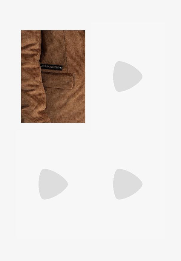 Ruskohvihta ruskea, jossa on vasemmalla puolella tasku ja etiketti, jossa on mustalla "Gráinne Kavanagh", näkyvät ompeluseikat kauttaaltaan.; Kaksi mustaa lyhythihaista poolopaitaa, puuvillamateriaalia, joissa on klassinen kaulus, kahden napin napitus ja valkoiset raidat kauluksen sisällä.; Mustat housut suoran lahkeen leikkauksella, valmistettu puuvillasekoitekankaasta. Varustettu metallinappikiinnityksellä ja sivutaskuilla. Ei näkyviä kuvioita.; Musta nahkainen liukujalkine, jossa on sileä pinta, ommeltuja yksityiskohtia, pyöristetty kärki ja matala kumipohja. Pohjassa on minimaalinen pito.