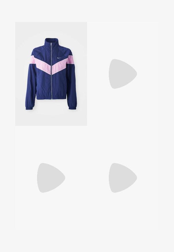Mornarska vetrovka z rožnatimi črtnimi vzorci, zadrgo spredaj, stojnim ovratnikom in elastičnimi manšetami. Lahka, gladka tkanina. Nike logo na prsih.; Beli kratek top iz mešanice bombaža. Ima izrez v obliki ključavnice na hrbtni strani in črne tiskane logotipne podrobnosti spredaj.; Roza hlače z elastiko v pasu in sproščenim fitom. Imajo rdeči logotip na levi strani in gladko, lahkotno teksturo.; Bela usnjena športna-obutev z rumenimi detajli, okrogli nos, in teksturiran gumijast podplat, v kombinaciji s temno modrimi razširjenimi jeans hlačami.