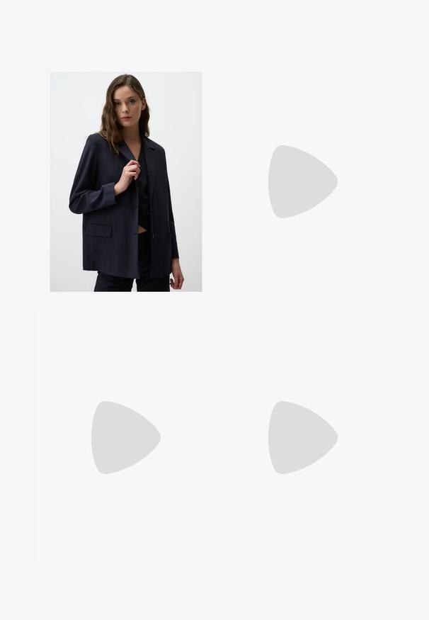 Blazer navy a righe sottili in tessuto leggero, con colletto a punta, chiusura frontale con un bottone singolo e dettagli con tasche laterali.; T-shirt bianco a maniche corte realizzato in cotone morbido. Presenta un collo rotondo e orlo dritto, senza fantasie né decorazioni.; Pantaloni neri a gamba larga con vita alta, dettagli con bottoni in vita e pieghe frontali.; Sandalo con tacco aperto nero, con cinturini incrociati, fibbia regolabile alla caviglia e tacco spesso, con una texture in pelle liscia.; Borsa nera con forma strutturata, texture liscia e una chiusura metallica. Abbinata a pantaloni neri larghi e sandali open-toe su un pavimento in legno.