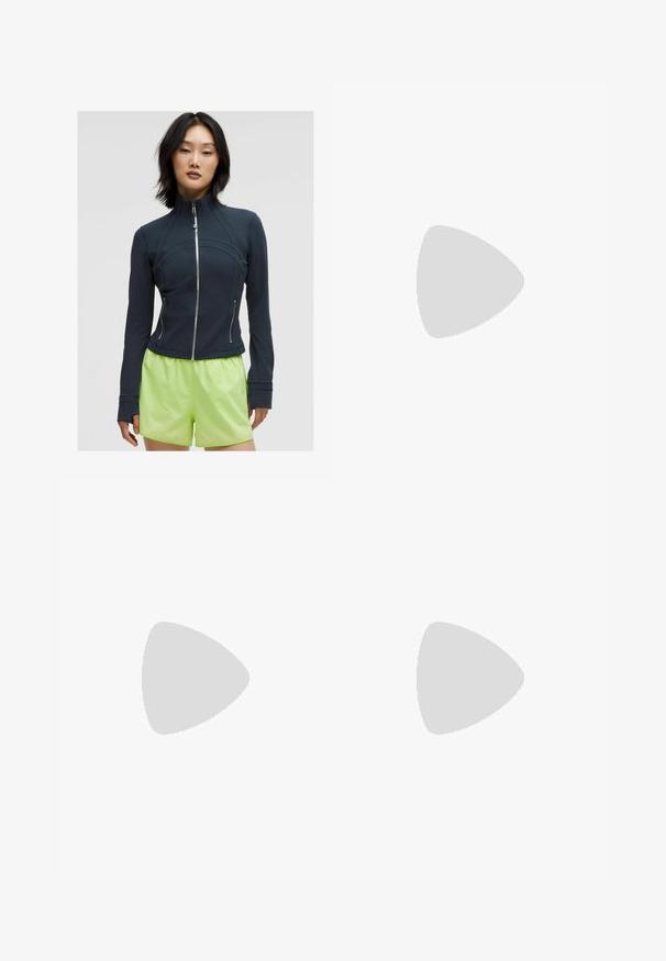 Marineblauwe zip-up jas met een hoge kraag. Glad, rekbaar materiaal met gebogen naden en twee zijritsen. Gecombineerd met fel limoen groene shorts.; Witte T-shirt met korte mouwen van gladde stof, met een ronde halslijn en een klein grijs Nike-logo op de borst.; Witte hoge taille shorts van rekbare stof. Kenmerken een gladde textuur en een aansluitend ontwerp, zonder extra patronen of hardware.; Witte sportschoenen met een gestructureerde bovenkant, gevoerde kraag en vetersluiting. Voorzien van een gebogen buitenzool en subtiele branding aan de zijkant.