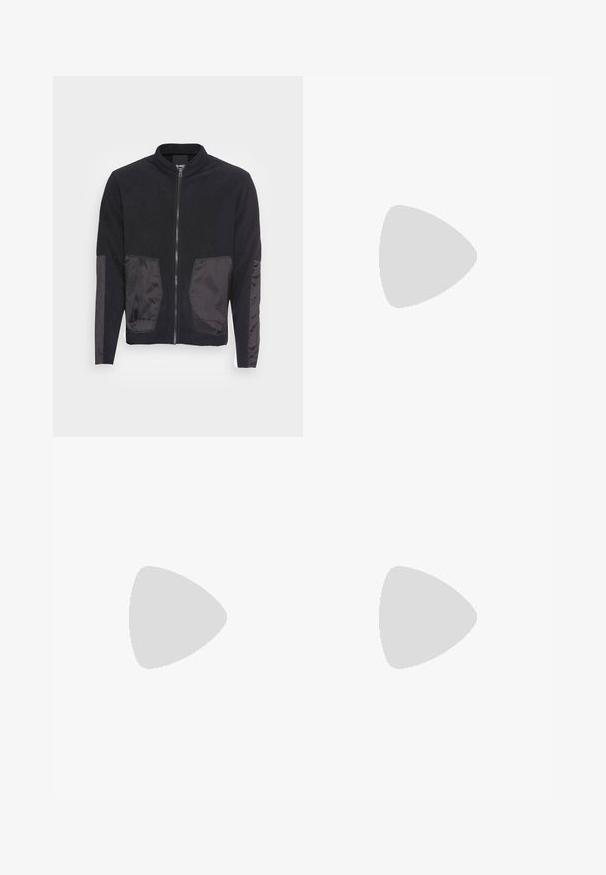 Denham TRECK JACKET - Casaco polar - black; Conjunto de t-shirts em algodão, com uma preta e uma branca, ambas com mangas curtas, decote redondo e corte standard. Tecido texturizado.; Calças pretas feitas de tecido suave, com um design de perna reta, dois pregas frontais e uma cintura padrão com passantes para cinto.; Ténis brancos com textura suave, apresentando elementos em pele castanha e detalhes em preto, combinados com calças pretas ajustadas. Fundo de chão de madeira.