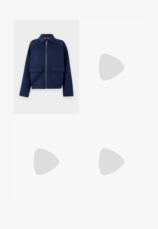 Marineblå kort jakke laget av myk stoff, med glidelås foran, spiss krage, og to store påsydde lommer.; Hvit langermet topp med høy hals, med en asymmetrisk hemline og teksturert stoff som faller mykt. Glatt, tettsittende design.; Marineblå, vidbukser laget av myk, elastisk stoff, med en glatt midjebånd og diskrete sidelommer.; Svart skinnballettflatt med rund tå, glatt tekstur, minimal sømdetalj, og et fleksibelt såledesign.