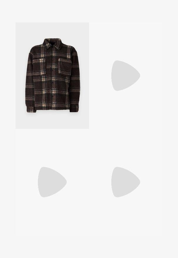 Giacca camicia in pile a quadri marrone con chiusura a bottoni, colletto aperto e una tasca sul petto; presenta un tessuto texturizzato e morbido.; T-shirt bianco a maniche corte con testo rosso "Studio Originals Edition" sul lato sinistro del petto, esposto su uno sfondo grigio neutro.; Jeans di denim azzurro chiaro con vestibilità ampia, vita media e gambe dritte. Presenta cinque tasche, passanti per cintura e chiusura con bottone.; Sneakers bianchi slip-on con superficie texturizzata, suola spessa e design minimalista. Presentano il logo del marchio sul lato.