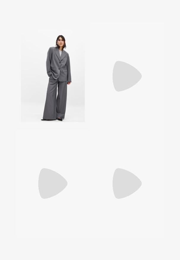 Grå pinstribet jakkesæt med en oversized jakke med store revers og vide bukser. Fuldsat med sort fodtøj for kontrast.; Hvid bomulds tanktop med brede stropper, en rund udskæring og en glat tekstur. Har et mærke på bagsiden af udskæringen til størrelsesinformation.; Sort stribet crop top med struktureret buste, parret med højtaljede, vide bukser. Glat stof og minimalistisk design.; Mænds mørkebrune læder penny loafers med sort sål og syning langs tåen, vist i sideprofil.