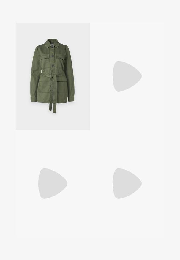 Veste verte olive en coton, présentant une fermeture à boutons, deux poches poitrine, une taille ceinturée et un col, avec des manches longues.; Chemise blanche à manches longues avec col, fermeture à boutons, deux poches poitrine, ourlet droit et manches légèrement évasées, fabriquée en tissu lisse.; Jean large en denim bleu foncé à taille haute, avec cinq poches, des coutures contrastées et des éléments en métal argenté. Texture lisse et finition soignée.; Baskets en daim noir avec accents blancs, arborant un logo doré. Portées avec un jean en denim bleu clair et posées sur une surface bleue texturée.