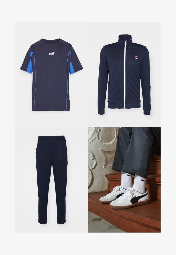 Marineblaue Trainingsjacke mit hohem Kragen, durchgehendem Reißverschluss, weißem Reißverschluss und kontrastierenden Ärmelakzenten, hergestellt aus einem glatten, dehnbaren Material.; T-Shirt mit kurzen Ärmeln in Marineblau mit blauen seitlichen Akzenten. Hergestellt aus weichem Stoff, hat einen Rundhals und ein weißes Puma-Logo auf der Brust.; Marineblaue Sporthosen mit einem elastischen Bund, seitlichen Taschen und Reißverschlüssen an den Säumen. Hergestellt aus glattem, dehnbarem Stoff.; Puma-Sneaker aus weißem und schwarzem Wildleder mit einer braunen Gummisohle. Kombiniert mit weißen Socken, die ein schwarzes Logo zeigen, getragen zu dunklen Hosen.