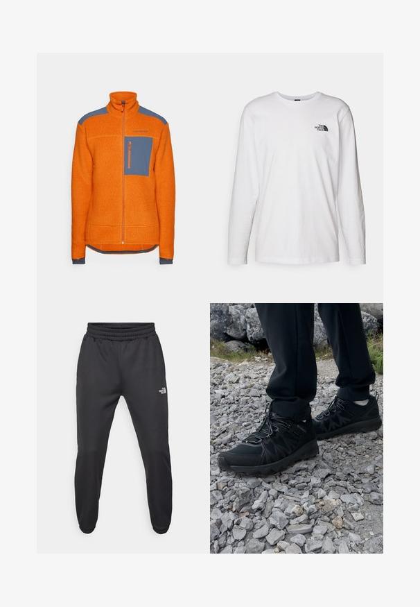 Pomarańczowa polarowa kurtka z wysokim kołnierzem, niebieskimi akcentami na ramionach, zapinaną na zamek kieszenią na piersi i ściągaczami na mankietach. Strukturalny materiał w całym kroju.; Biała koszulka z długim rękawem wykonana z bawełny, z okrągłym dekoltem. Posiada małe czarne logo na piersi. Gładka faktura, regularny krój.; Czarne dresy z elastycznym paskiem w talii, zwężanym krojem, elastycznymi mankietami i małym białym logo na lewej udzie, wykonane z gładkiego materiału.; Czarne buty outdoorowe wykonane z siateczki i materiału syntetycznego, z fakturowaną cholewką, zabezpieczonym systemem sznurowania i solidną podeszwą, na skalistym terenie.