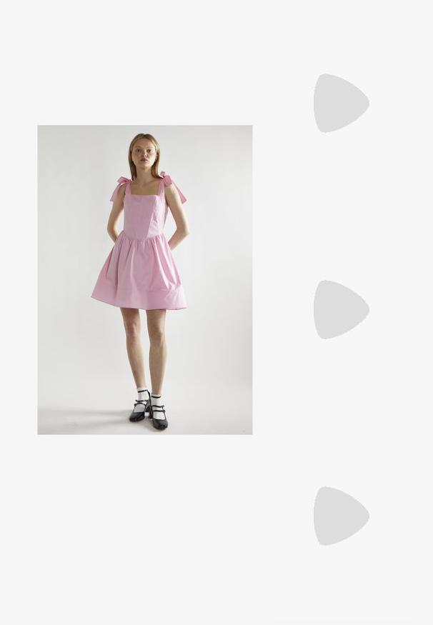 Monivärinen, sidottava T-paita, jossa on graadiantin kuvio pinkin, sinisen ja vihreän sävyissä. Lyhyet hihat ja pyöreä pääntie. Puuvillasekoitekangas.; Vaaleanpunainen puuvillamekko neliön muotoisella pääntiellä, laskostetulla hameella ja solmittavilla olkaimilla. Yhdistetty mustiin Mary Jane -kengiin ja valkoisiin frillireunaisiin sukkiin.; Mustat nahka nilkkurit, joissa on pussimainen muotoilu, nelikulmainen kärki ja sivuistukko. Paksu pohja lisää korkeutta ja vakautta.; Violetti suorakulmaiset aurinkolasit tummilla laseilla, joita käytetään ruusu- ja kirkkaanvärisen kukkakuosiset poolopaidan kanssa.; Vaalea vaaleanpunainen lakattu nahkakäsilaukku, jossa on suorakulmainen muoto, irrotettava ketjun olkaimet ja hopeiset yksityiskohdat edessä.