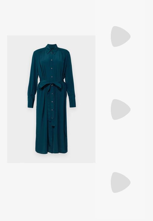 Satin slipdress in lichtgroen met bloembroderie op één schouder. Verstelbare spaghetti bandjes, recht model en een gladde textuur.; Teal lange mouw jurk van een gladde stof, met een knoopsluiting aan de voorkant, kraag en een tailleband voor een verstelbare pasvorm. Smalle manchetten aan de mouwen.; Witte haksandalen met een vierkante neus, twee slanke bandjes en een gesp om de enkel; glinsterende zilveren accenten op de hak.; Grijze neplederen handtas met een gebogen vorm, voorzien van zwarte biezen, een enkele schouderband en een extra afneembare band.