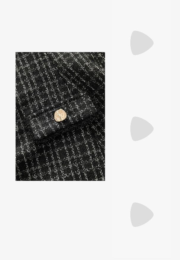 Tela texturizada en blanco y negro con un patrón de cuadros, con un botón metálico dorado en la parte frontal. Material suave y tejido.; Zapatillas de ante negras con una francha lateral blanca, diseño de cordones y suela de goma color caramelo. Detalle del logo dorado en el lateral.; Gafas de tortuga con montura ovalada, lentes claros y detalles en dorado. Presentan patillas curvadas y un acabado suave y brillante.; Bolso hobo de cuero marrón con un diseño relajado y textura suave. Llevado de manera casual por un modelo, presenta una gran apertura y forma redondeada.