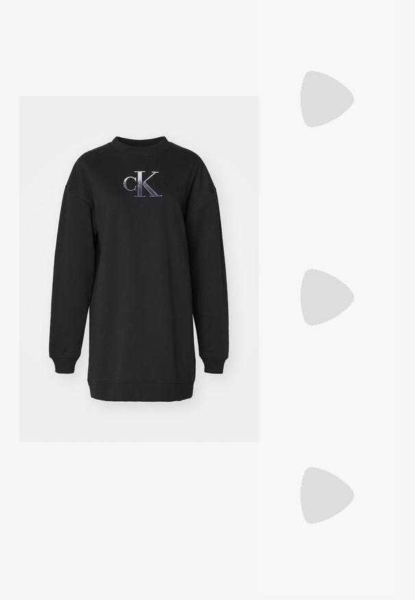 Črna majica s kapuco iz mehkega materiala, z okroglim izrezom, oversized krojem in vezenim "CK" logotipom v sivi in beli barvi na sprednji strani.; Svetlo bež rebrast turtleneck dolg rokav top z oprijetim dizajnom in visokim ovratnikom. Ima subtilno oznako logotipa na robu. Gladka tekstura.; Sive športne čevlje iz semiša z belimi vezalkami, črnimi črtami in belim gumijastim podplatom. Imajo okroglo oznako na ježku in podplat iz gume.; Srebrni obročasti uhani s poliranim finišom, ki se ponašajo s krožno zasnovo in brezšivnimi tečaji ter gladko teksturo.