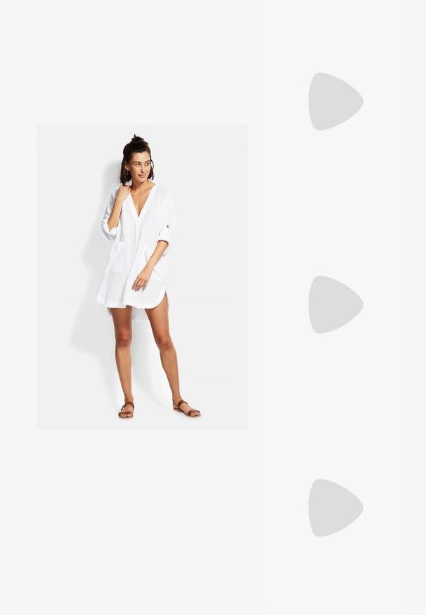 Bílá, lehká košilová šaty s výstřihem do V, tříčtvrtečními rukávy, předními kapsami a volným střihem. Obsahují minimální detaile šití.; Černé lakované lodičky s otevřenou patou, špičatou špičkou, zaobleným střihem a blokovým podpatkem. Zdobené akcentem v zlatém tónu.; Černé oversized sluneční brýle se gradientními skly, silnými rámy a zlatými řetízkovými detaily na nožičkách.; Černá taška přes rameno vyrobená z umělého materiálu, s jednoduchým obdélníkovým designem, zlatými čtvercovými akcenty a dvojitými uchy.