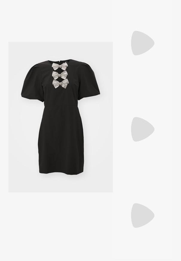 Črna obleka s kratkimi napihnjenimi rokavi, ki ima dekorativen niz srebrnih diamantek v obliki pentelj na izrezu. Gladka tkanina, prilegajoča silhueta.; Črne usnjene balerinke, koničast toe, minimalističen dizajn, gladka tekstura, nizka peta, brez vidnih kovinskih delov ali okraskov.; Črna usnjena torba čez ramo z gladko teksturo, pravokotno obliko in kovinskim verižnim detajlom spredaj. Vključena je nastavljiva naramnica.; Srebrn dvojni prstan z gladko, polirano površino. Ima tekoč, ukrivljen dizajn z prekrivajočimi se sekcijami za sodoben videz.