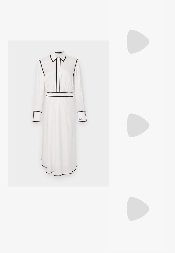 Robe chemise blanche avec bordures noires, col chemise, manches longues, fermeture à boutons sur le devant et une silhouette en A. Présente des détails brodés sur la manche.; Des sandales noires à talons hauts avec des fines lanières au design noué, un bout carré lisse et un talon aiguille élégant.; Sac à main en métal gris clair avec une bandoulière en chaîne, orné de petits clous métalliques ronds et d'un logo de marque triangulaire.; Boucles d'oreilles en argent avec une finition lisse et brillante. Forme arrondie, conception légère, avec un fermoir à tige.