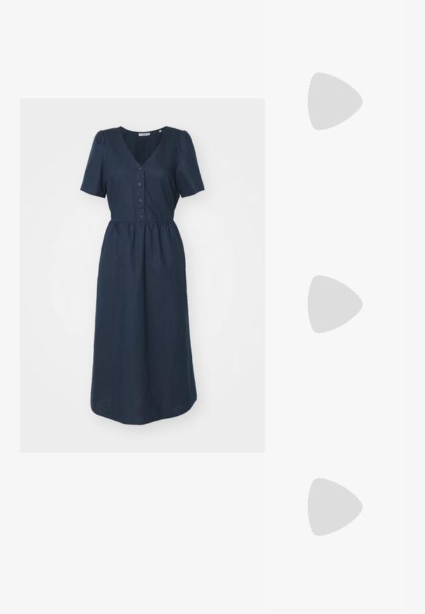 Marineblaues, kurzärmeliges Kleid mit V-Ausschnitt, Knopfverschluss und gerafftem Taillenbereich, das eine glatte Textur und eine Knöchellänge aufweist.; Schwarze Lackleder-Slingback-Absätze mit spitzer Zehenform, einem runden Ausschnitt-Design und einem Blockabsatz. Mit einem goldfarbenen Schnallenakzent.; Schwarze übergroße Sonnenbrille mit getönten Gläsern, dicken Rahmen und goldfarbener Kettendetaillierung an den Bügeln.; Schwarze Handtasche mit strukturierter Form, glatter Textur und einem metallischen Verschluss. Kombiniert mit weiten schwarzen Hosen und offenen Sandalen auf einem Holzboden.