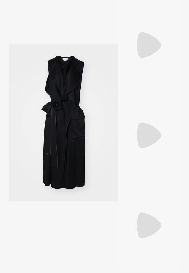 Black sleeveless wrap dress with a front drape, features a tie belt, angled pockets, and subtle white stitching along the edges.; Gold metallic pointed-toe high heel shoe with stiletto heel, shown from the side on a plain light background.; Black leather shoulder bag with a curved shape, thin handle, and subtle gold accents. Smooth texture with minimalistic design.; Gold-tone metal hoop earrings with a curved, elongated shape. Features a smooth, shiny surface and a rounded tip for added detail.