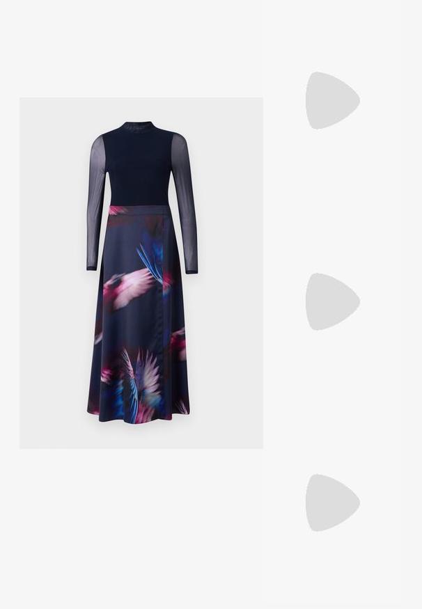 Robe à manches longues avec un corsage ajusté bleu marine et une jupe fluide ornée d'un imprimé de plumes vibrant dans des tons de rose, bleu et violet.; Des sandales noires à talons hauts avec des fines lanières au design noué, un bout carré lisse et un talon aiguille élégant.; Sac à main en métal gris clair avec une bandoulière en chaîne, orné de petits clous métalliques ronds et d'un logo de marque triangulaire.; Boucles d'oreilles en argent avec une finition lisse et brillante. Forme arrondie, conception légère, avec un fermoir à tige.