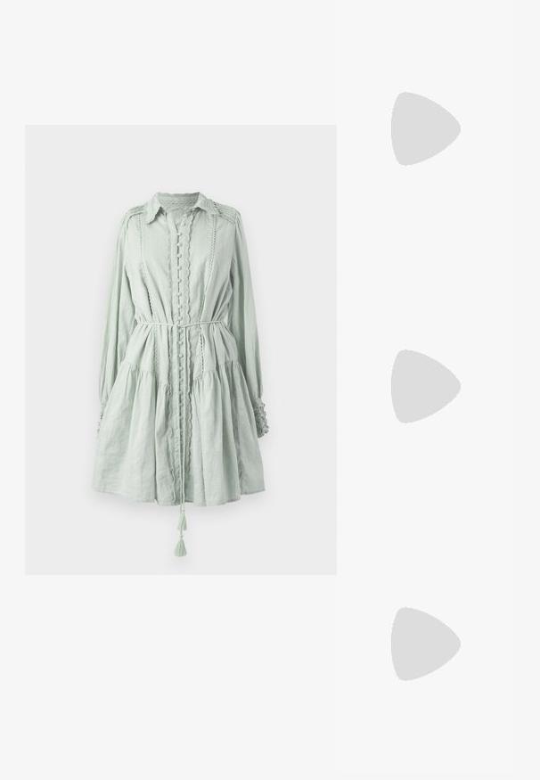 Ljusgrön klänning med lång ärm i texturerad tyg. Har knäppningar, volangkant och midja med dragsko och tofsdetaljer.; Silverfärgad metallisk slingback-sandal med låg klack, som har korsade remmar och en slät yta. Minimalistisk design.; Svart läderhandväska med en böjd form, avtagbar rem och guldiga detaljer. Väskan har ett lock med en spänndetalj.; Örhänge i guldtonad metall med en elegant, böjd design. Har en distinkt spetsig form, polerad yta och gångjärnslås.