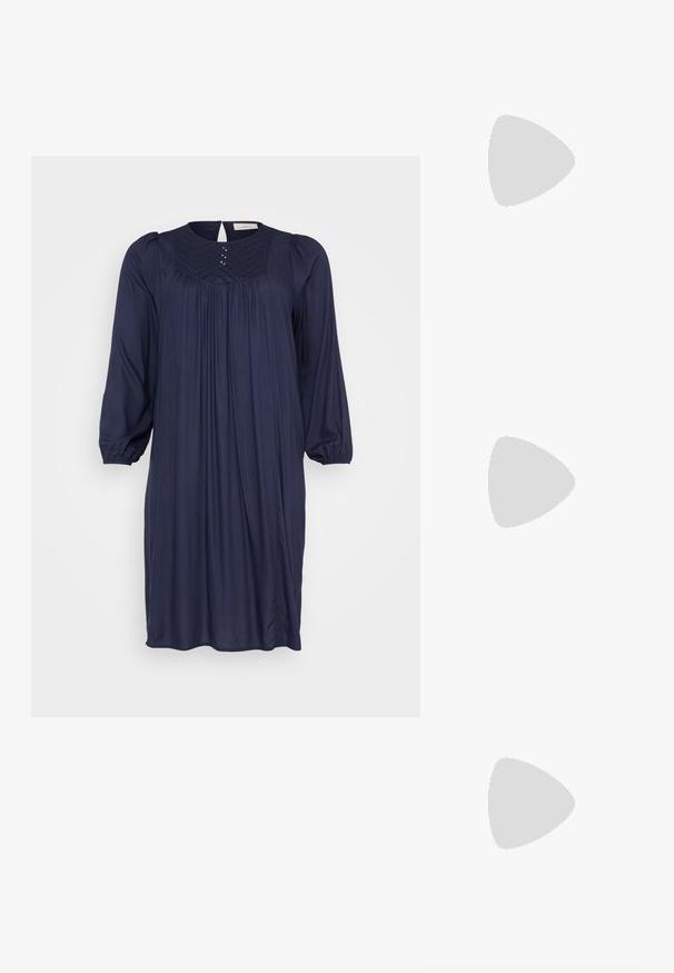 Tamsiai mėlyna suknelė su apykakle, susiūta priekyje su klostėmis ir trimis ketvirtadaliais pūstomis rankovėmis. Akcentuoja mažos dekoratyvinės smeigės aplink apykaklę.; Juodai odiniai aukštakulniai batai su apvaliu pirštu ir vidutiniu bloku. Lygi tekstūra su minimaliu apdailos, turinčia subtilų elastingą atidarymą.; Juodas odinis petinis krepšys su lygiu paviršiumi, išlenkta forma, reguliuojama dirželiu ir užtrauktuku. Minimalistinis dizainas be puošmenų.; Sidabrinis dvigubas žiedas su lygiu, poliruotu paviršiumi. Pasižymi sklandžiu, kreiptu dizainu su persipinančiomis dalimis, suteikiančiomis modernų išvaizdą.