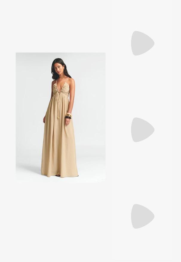 Dolga bež maksi obleka z globokim V-izrezom, nabranim dekoltejem in nastavljivim trakom. Lahka tkanina se ohlapno spušča do tal.; Rjavi lakirani loafer z kvadratnim nosom, kovinsko verigo kot okrasom in nizko blok podplatom; gladka tekstura, minimalističen dizajn.; Heksagonalne sončne očala z rjavimi gradientnimi lečami, prosojnim bež okvirom in temno rjavimi ročaji. Na strani je blagovna znamka "vogue".; Tan gamasti torbica z naramnicami, ukrivljene oblike, z zlatimi detajli in zadrgo. Ima dodan čar s inicialkami "MK."