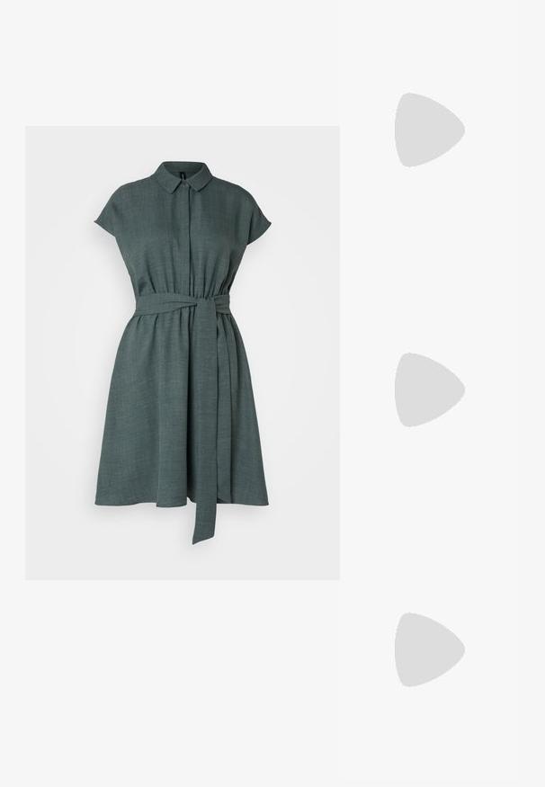 Vero Moda VMMELONY SHORT DRESS - Abito a camicia - balsam green; Décolleté in vernice nera con punta affusolata e tacco in geometria cubica. Presentano un design elegante e minimalista, con una texture liscia.; Borsa a tracolla nera in pelle con una forma curva, manico rimovibile e accessori dorati. La borsa presenta una patta con un dettaglio a fibbia.; Anello in tono oro con un design organico e Twisted, caratterizzato da una superficie liscia e punte affusolate, che crea un aspetto moderno e scultoreo.
