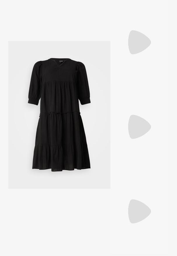 Vestido negro de corte en capas con escote en V, mangas abullonadas y puños elásticos. Confeccionado en una tela ligera, presenta una silueta fluida y una textura sutil.; Zapato de tacón negro de cuero con punta afilada y tacón bajo cuadrado. Presenta una correa para el tobillo con una hebilla en tono dorado. Textura suave.; Gafas de sol negras de gran tamaño con lentes degradados, montura gruesa y detalles de cadena en tono dorado en las patillas.; Bolso negro con forma estructurada, textura suave y un cierre metálico. Combinado con pantalones anchos negros y sandalias de dedo en un suelo de madera.