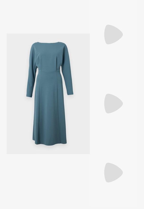 Robe à manches longues en tissu vert canard, avec un col rond, un buste cintré et une jupe fluide avec une couture à l'avant pour la structure.; Baskets en cuir blanc avec une épaisse semelle blanche, un accent en daim noir au niveau du talon et un logo embossé sur le côté. Design à lacets avec six œillets.; Lunettes de soleil noires surdimensionnées avec une forme géométrique, dotées de verres foncés et d'un détail gris contrastant sur la monture. Logo sur la branche.; Boucles d'oreilles en argent avec une finition lisse et brillante. Forme arrondie, conception légère, avec un fermoir à tige.