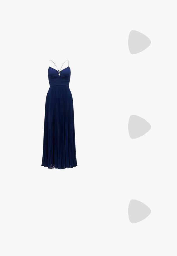Rochie de seară plisată de culoare bleu marin, cu un corset ajustat, bretele subțiri și un accent decorativ din piatră prețioasă sub decolteu.; Sandaie cu toc alb, cu vârful ascuțit, material superior neted, toc mic tip bloc și design cu decupaj lateral, cu curea ajustabilă.; Ochelari de soare rotunzi cu lentile întunecate și rame aurii. Modelul poartă un cardigan ribbed de culoare albastru deschis cu nasturi și mâneci albe în contrast.; Clutch Michael Kors din canva acoperit bej, cu un model repetitiv al logo-ului MK, accesorii din aur și o curea cu lanț detașabil.