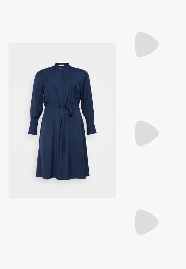 Tamsiai mėlyna suknelė, ilgomis rankovėmis, apvaliu krūtiniu, su surišta juosimi ir dirželiu, iki kelių ilgio, pagaminta iš lygaus audinio su sagčių uždarymu priekyje.; Juodi šlepetės su kvadratiniu pirštu ir žemu bloku kulnu. Yra keli ploni dirželiai ir reguliuojamas kulkšnies diržas. Pagaminti iš lygios odos.; Juodas odinis nešiojamas krepšys su lygiu paviršiumi, struktūrine forma, dviem rankenėlėmis ir ryškiu sidabriniu sagties akcentu priekyje.; Sidabrinis dvigubas žiedas su lygiu, poliruotu paviršiumi. Pasižymi sklandžiu, kreiptu dizainu su persipinančiomis dalimis, suteikiančiomis modernų išvaizdą.