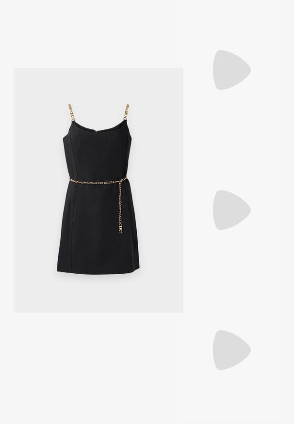 Vestido preto sem mangas com alças de corrente dourada e um cinto de corrente dourada. Tecido suave, design ajustado e uma discreta gola em V.; Sapatilhas de couro brancas, design de cano baixo, com textura suave, biqueira redonda, atacadores à frente e um pequeno logótipo bordado na lateral.; Bolsa em forma de meia-lua de couro preto com um detalhe em metal dourado, apresentando um fecho de zíper. Usada de forma transversal sobre um suéter cinza.; Brincos de pressão em tom dourado com um design torcido. Cada brinco possui uma base circular transparente para um uso seguro.