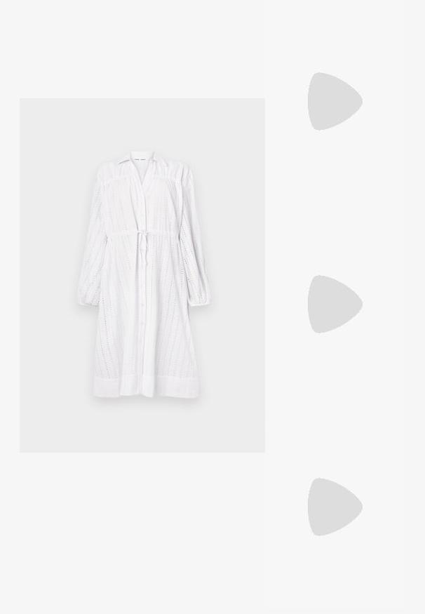 Biała sukienka z długim rękawem, z guzikami z przodu, związywana w talii, z wzorem w kółka i bufkami. Gładka tekstura, luźny krój.; Czarne sandały na wysokim obcasie mają cienkie paski z węzłowym wzorem, gładki, kwadratowy czubek i smukły obcas w stylu szpilki.; Jasnoszara metaliczna torebka na łańcuszku, ozdobiona małymi okrągłymi metalowymi ćwiekami oraz trójkątnym logo marki.; Srebrne kolczyki na biglu o gładkim, błyszczącym wykończeniu. O zaokrąglonym kształcie, lekkim designie, z zamknięciem na zatrzask.