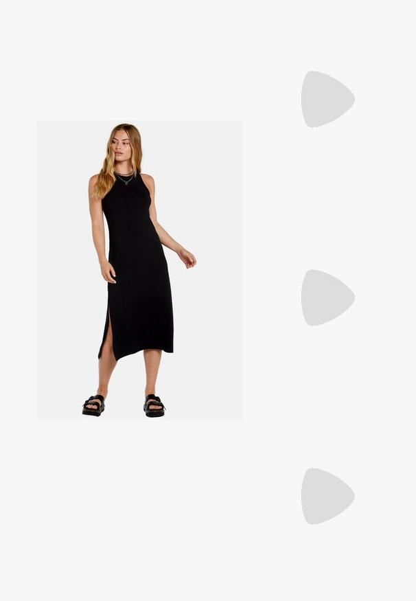 Vestido maxi negro sin mangas con aberturas laterales, hecho de una tela suave. Presenta una silueta ajustada y un escote redondo.; Zapato de tacón alto plateado tipo slingback con punta afilada, acabado metálico, dos correas decorativas y un tacón delgado con punta negra.; Bolso de mano metálico plateado con forma estructurada, que presenta un asa superior y un detalle de lazo en el frente. Textura suave y acabado reflectante.; Pendientes en forma de corazón plateados que presentan piedras claras facetadas, con un marco texturizado. El conjunto incluye estilos de perno y tipo gota.