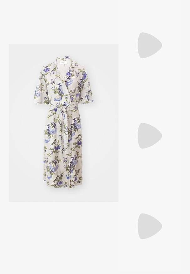 Robe wrap florale en tissu léger, avec des manches courtes évasées, une taille à nouer et des motifs floraux violets et verts sur un fond clair.; Escarpins noirs en cuir verni avec un bout pointu, sangle ajustable à la cheville et un talon bloc modéré. Texture lisse avec finition brillante.; Sac à main en cuir marron avec un design courbé, une anse crème, des accessoires dorés et une bandoulière détachable. Présente des détails de couture blanche.; Boucle d'oreille en or avec un petit accent de gemme décoratif. Portée par un modèle aux cheveux raides, associée à une chemise blanche à col.