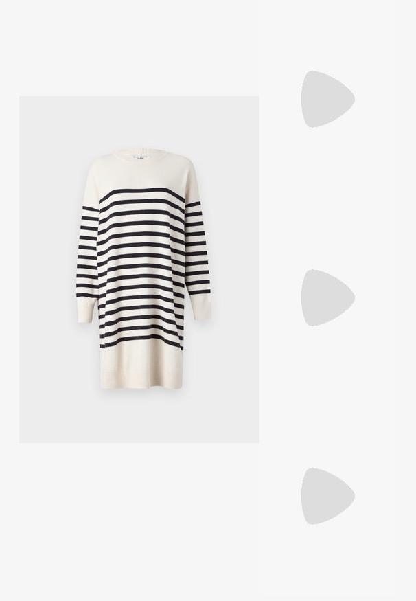 Cream sweater dress with black stripes, long sleeves, ribbed cuffs, and rounded neckline. Soft texture; knee-length design.; Patent burgundy high-heeled sandal with an open toe, featuring cross straps and an ankle strap with a round gold buckle. Block heel design.; Black handbag with structured shape, smooth texture, and a metallic clasp. Paired with wide black pants and open-toe sandals on wooden floor.; Silver-tone earrings in a twisted hoop design, featuring a textured surface and ribbed detailing, secured with a post clasp.