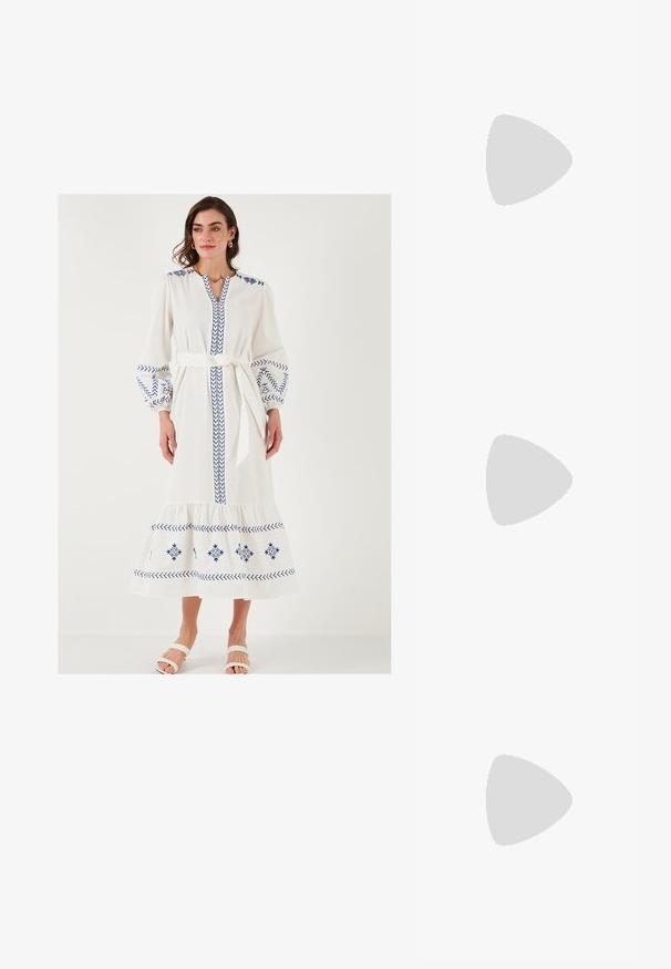 Valge pikk kleit siniste tikanditega, balloonvarrukatega, V-avaga ja nööriga talje juures. Omab kihilist allääret ja pehmet tekstuuri.; Köitmine kõrge kontsaga sandaal valgest nahast, millel on stiilne disain, läbipaistev plokk-konts ja dekoratiivne element varvaste juures.; Prunade gradientiga prillid koos poolka sellest roosast raamistikust, ruudukujulised ning õhukeste metallist kätega. Omab ümarate servadega ja minimaalset detailide taset.; Valge struktureeritud käekott lühikeste käepidemete ja õlavööga, millel on kuldse riistvara aktsendid ja tekstuuriga materjal, eksponeeritud halli taustal.