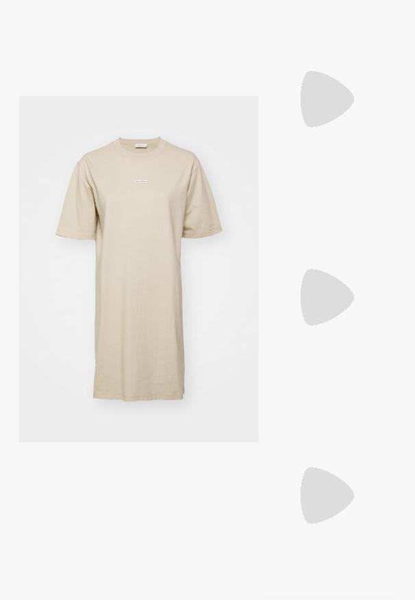 Beige pamut T-shirt ruha laza fazonnal, rövid ujjakkal és egy kis fehér "Calvin Klein" logóval a mellet. Simás textúra.; Világos bézs bordás garbó, hosszú ujjú, testhezálló fazonnal és magas nyakkal. Diszkrét logó címke található a szegélyen. Sima textúra.; Fekete lakk bőr loaferek, lekerekített orral, díszítő pánttal és ezüst színű részletekkel az elején. Négyzet alakú sarokkal és texturált talppal.; Fekete, téglalap alakú napszemüveg vastag kerettel, arany hardware részletekkel. A modellen világos bézs, bordázott garbó található.