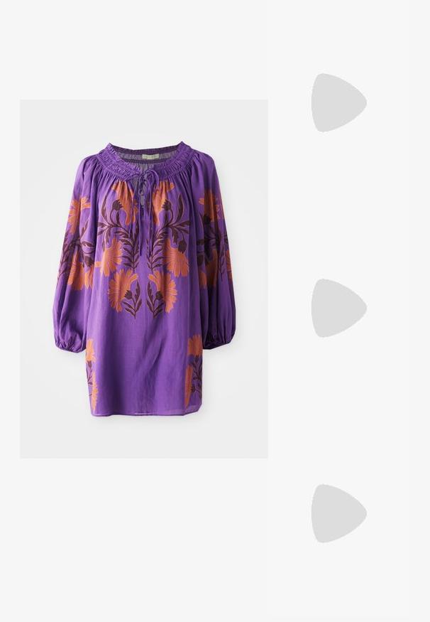Paarse blouse met een geplooide halslijn, lange ballonmouwen en oranje bloemendessin. Lichtgewicht stof met een vloeibare textuur.; Zwarte leren slidersandalen met een open teen, een platte zool en een decoratieve gouden accent op de bovenkant. Glad textuur met een minimalistisch design.; Zwarte gewatteerde leren handtas met een gathered bovenkant, gouden kettinghengsel en een rechthoekige vorm, vastgehouden tegen een effen achtergrond.; Gouden ketting met een centraal vierkant geslepen heldere edelsteen hanger en een verstelbare ketting. Getextureerde schakels met een karabijnhaaksluiting.