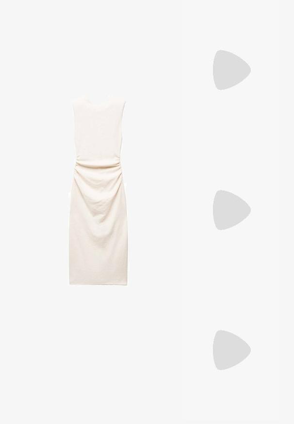 Mango Etui-jurk - beige; Zwarte gepatenteerde leren loafer met een vlakke zool, ronde teen en een decoratieve band met een gouden accen. Gladde, glanzende afwerking.; Zwarte rechthoekige zonnebril met dunne gouden metalen monturen, voorzien van gekleurde lenzen en kleine decoratieve accenten aan de zijkanten.; Zwarte handtas met gestructureerde vorm, gladde textuur en een metalen sluiting. Gecombineerd met brede zwarte broeken en sandalen met open teen op een houten vloer.